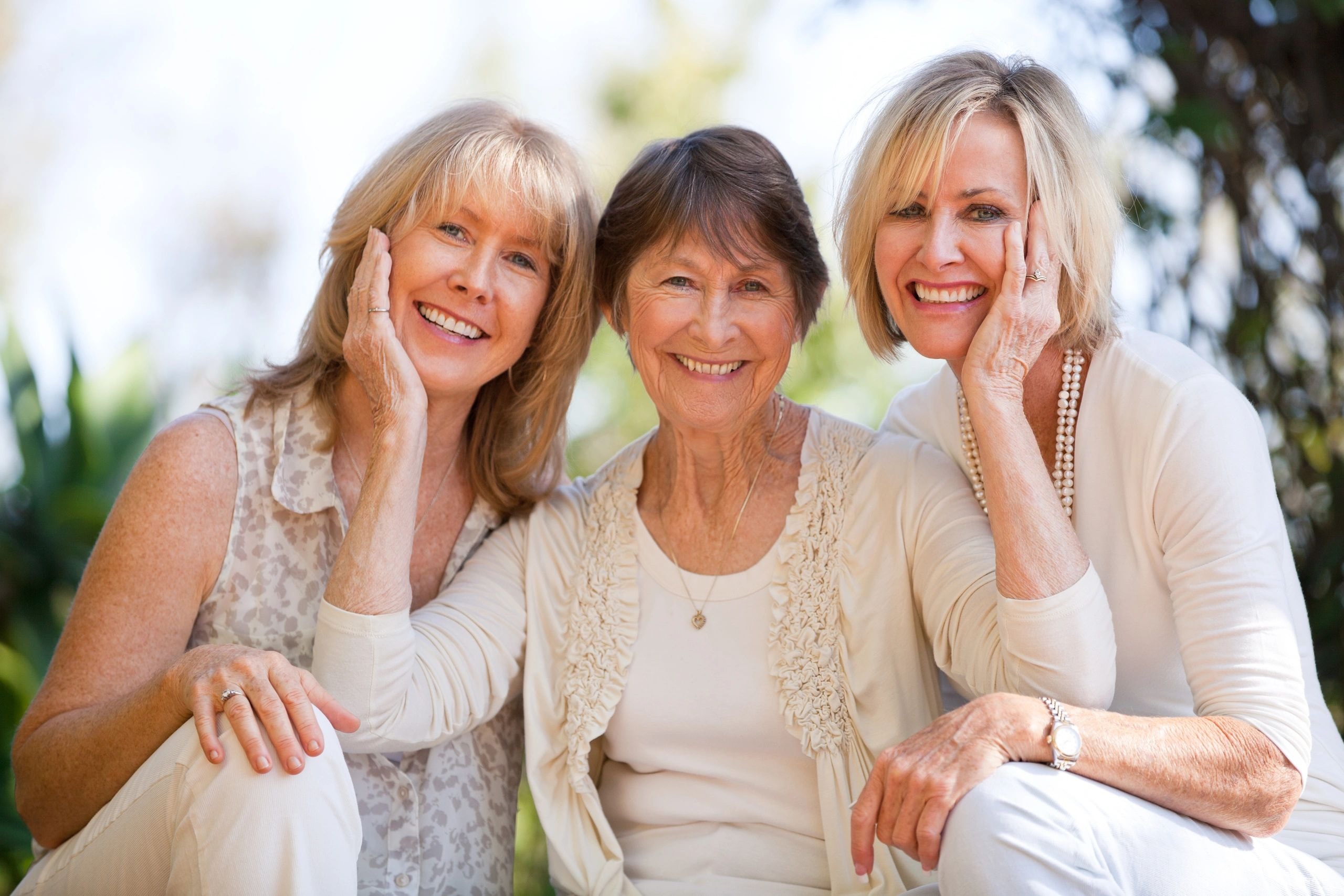 Three smiling mature women in a garden setting